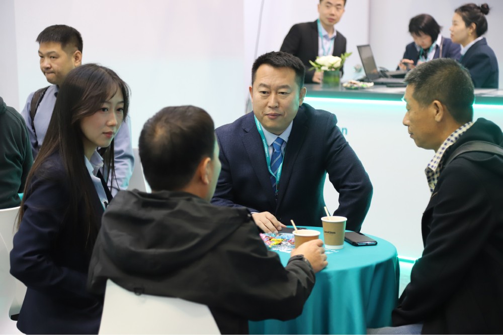 Visitors discussing vacuum glass applications with the LandVac team